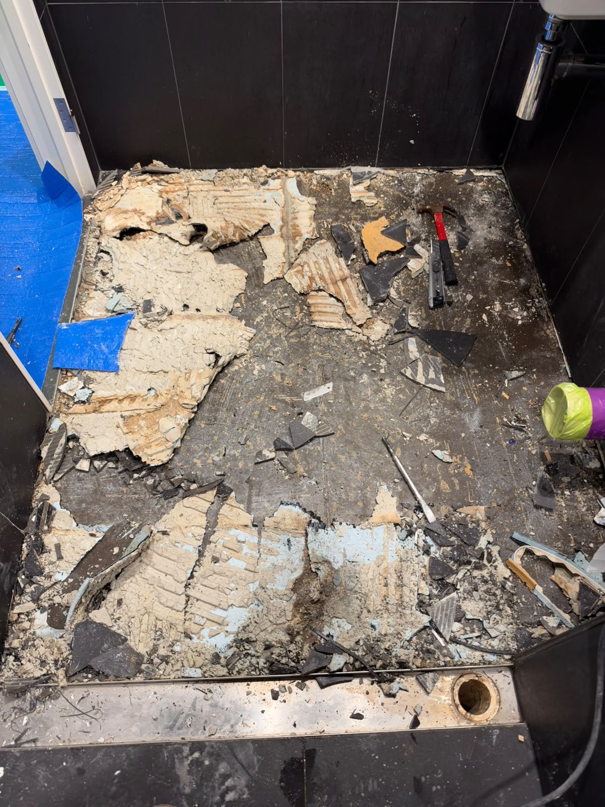 Outdoor tiled floor stripped back to substrate above stainless strip drain — Melbourne