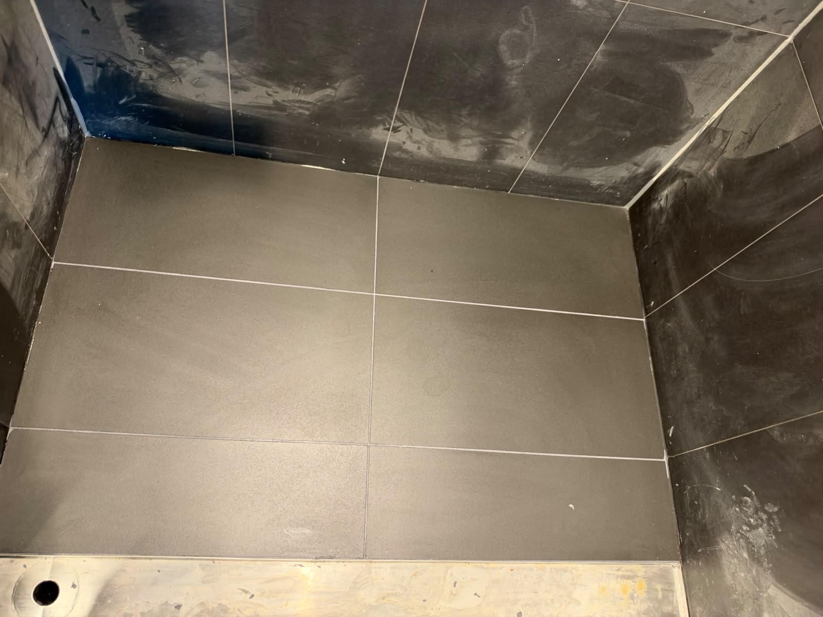 Completed outdoor floor tiling and clean grout joints above stainless strip drain — Melbourne